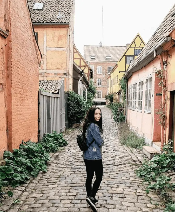 Girl walking down a narrow alley in Denmark