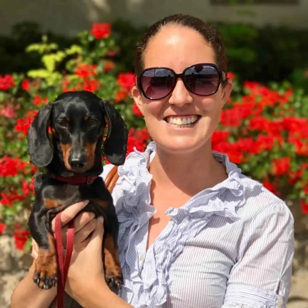 A woman holding a small dog